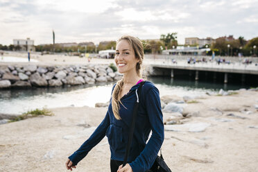 Junge Frau beim Spaziergang am Strand - GIOF01754