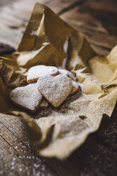 Heart-shaped shortbreads sprinkled with icing sugar on paper - GIOF01778