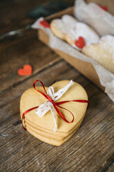 Stack of four heart-shaped shortbreads tied with lace and ribbon on wood - GIOF01788