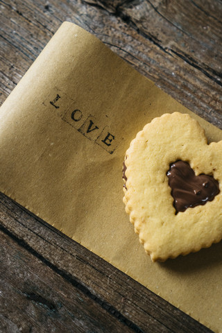 Heart-shaped Shortbread with chocolate filling on paper with the word 'love' stock photo