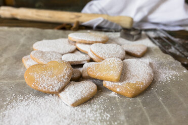 Heart-shaped shortbreads sprinkled with icing sugar on parchment paper - GIOF01803