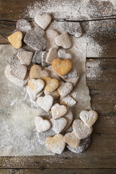 Various shortbreads sprinkled with icing sugar on paper and wood - GIOF01805