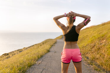 Young woman looking at the sea after workout - MGOF02888