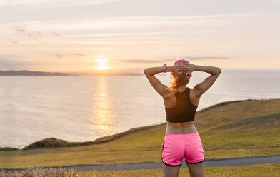 Young woman looking at the sea after workout - MGOF02900
