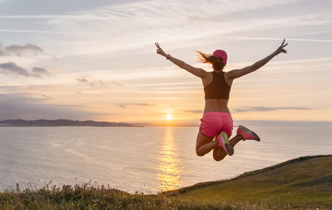 Weibliche Athletin springt vor Freude, lizenzfreies Stockfoto