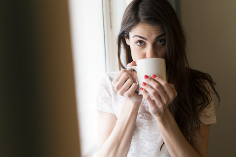 Porträt einer Frau, die eine Tasse Kaffee trinkt, lizenzfreies Stockfoto