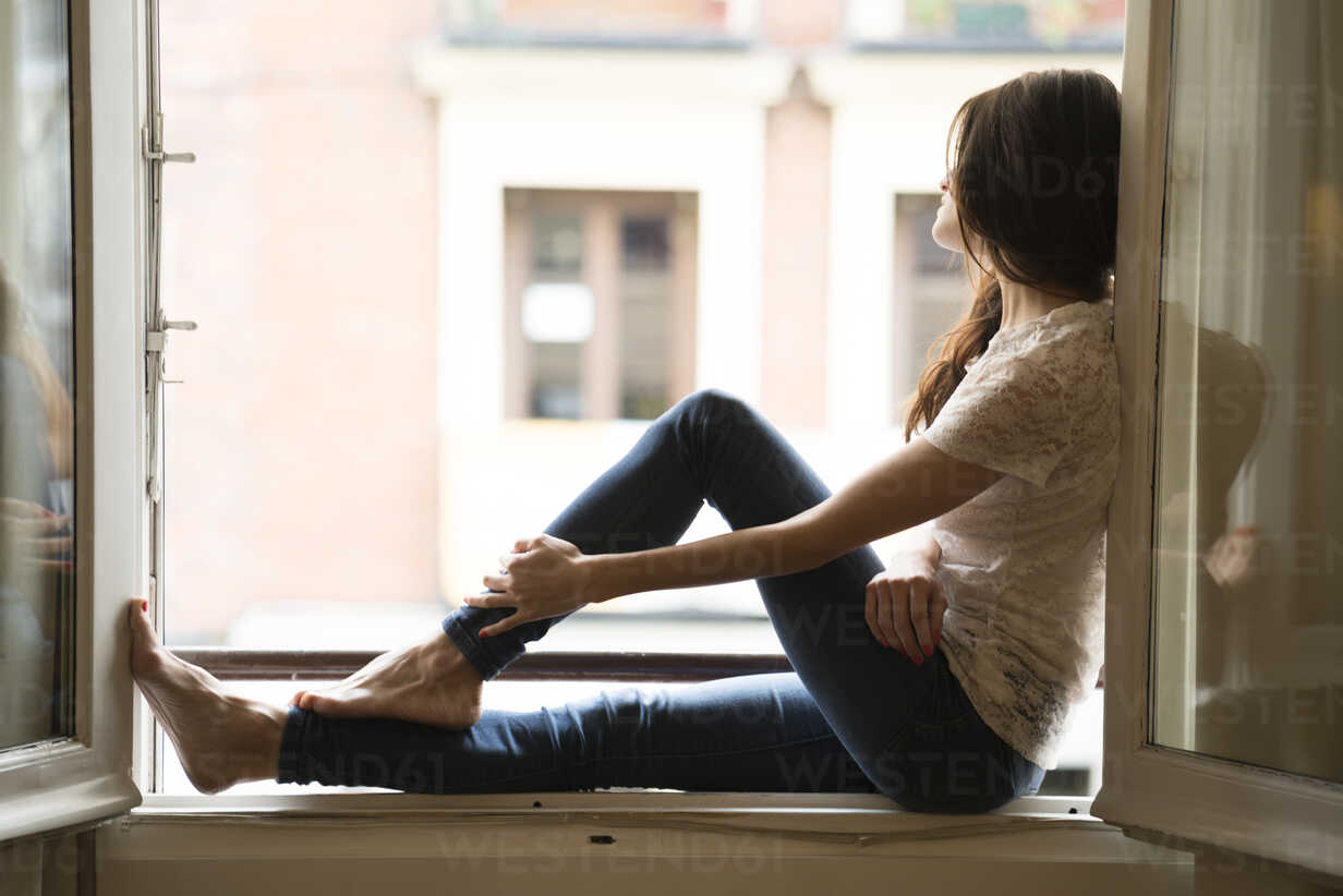 Woman sitting on window sill Stock Photo by DragonImages PhotoDune