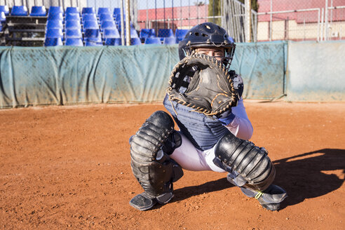 Weiblicher Fänger, bereit, den Ball während eines Baseballspiels zu fangen - ABZF01856