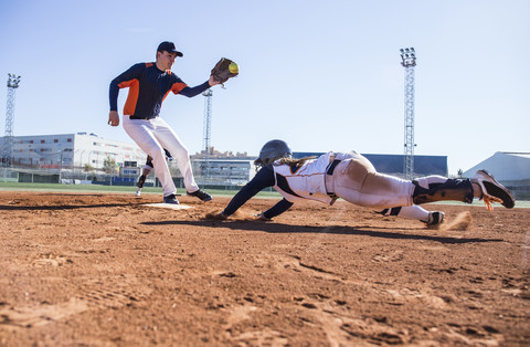Baseballspieler, der während eines Baseballspiels zur Base gleitet, lizenzfreies Stockfoto