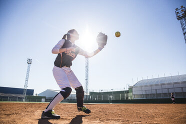 Female baseball player catching the ball during a baseball game - ABZF01887