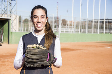 Portrait of smiling female baseball player with a baseball glove - ABZF01890