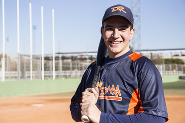 Porträt eines lächelnden Baseballspielers mit einem Baseballschläger - ABZF01891