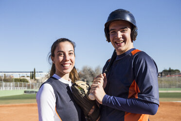 Portrait of smiling male and female baseball player - ABZF01894