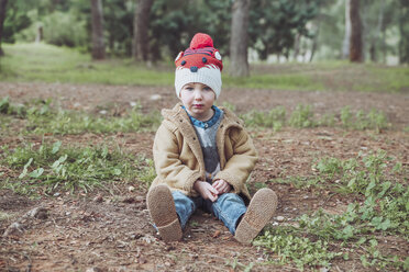 Portrait of boy wearing wooly hat sitting inforest - RTBF00626