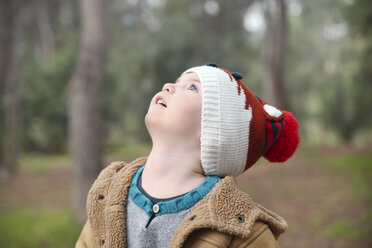 Boy wearing wooly hat in forest looking up - RTBF00630