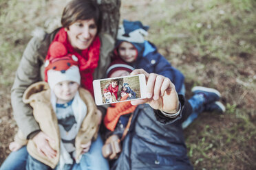 Family taking a selfie with smartphone in forest - RTBF00636