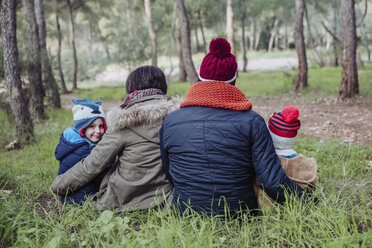 Rückansicht einer im Wald sitzenden Familie - RTBF00643