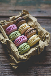 Different macarons in a box on wood - GIOF01813