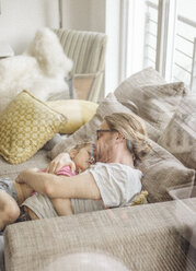 Vater entspannt sich mit Tochter auf Sofa - JOSF00489