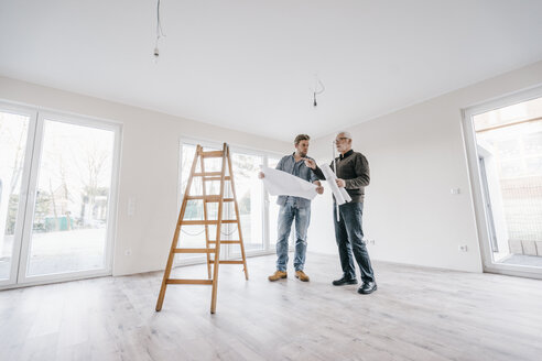 Architekt prüft Bauplan mit Bauherrn des neuen Hauses - JOSF00490