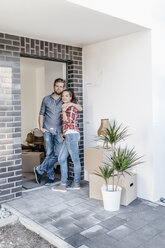 Ein glückliches Paar steht in der Tür seines neuen Hauses - JOSF00495
