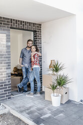 Happy couple standing in door of their new home - JOSF00495