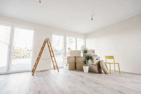 Moving boxes and ladder in empty room of a new home - JOSF00500