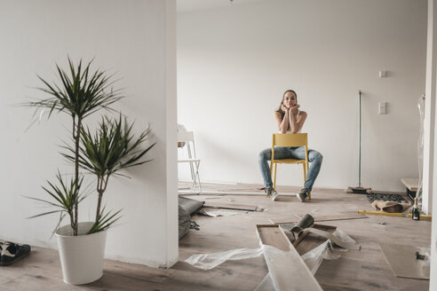 Mature woman moving house, sitting on chair - JOSF00508