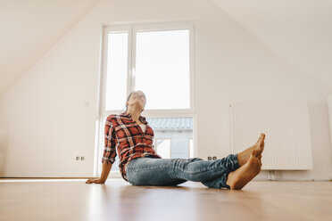 Mature woman moving house, sitting on floor, thinking - JOSF00525