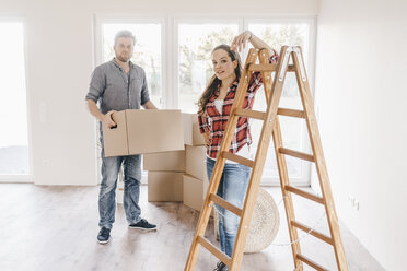 Ehepaar zieht um, trägt Kisten in die neue Wohnung - JOSF00529