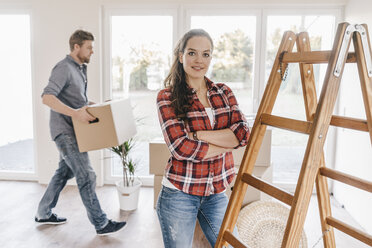 Ehepaar zieht um, trägt Kisten in die neue Wohnung - JOSF00530