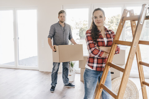 Ehepaar zieht um, trägt Kisten in die neue Wohnung, lizenzfreies Stockfoto