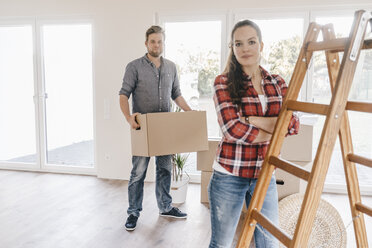 Couple moving house, carrying boxes in new home - JOSF00531