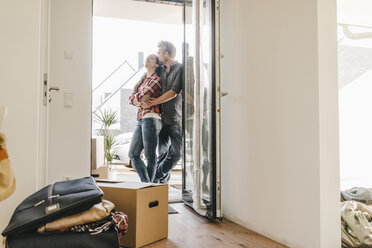 Happy couple standing in door of their new home - JOSF00535