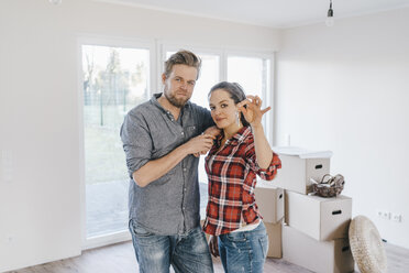 Couple moving house, woman holding keys of new home - JOSF00539