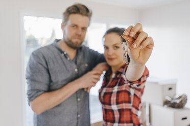 Couple moving house, woman holding keys of new home - JOSF00540