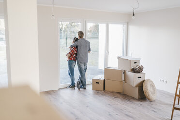 Ein glückliches Paar steht am Fenster seines neuen Hauses - JOSF00543