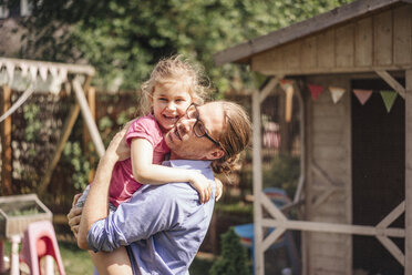 Father carrying daughter in garden - JOSF00607