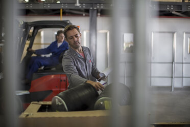 Factory worker in truck manufacture inspecting components - ZEF12758