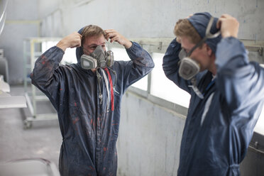 Factory worker in truck manufacture adjusting respirators - ZEF12790