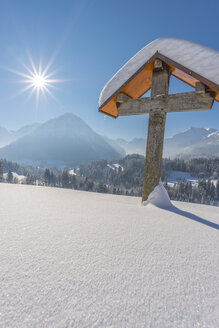 Deutschland, Oberstdorf, Oytal, schneebedecktes Feldkreuz im Gegenlicht - WGF01051