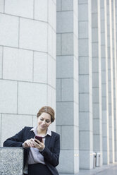 Lächelnde Geschäftsfrau mit Mobiltelefon - WESTF22616