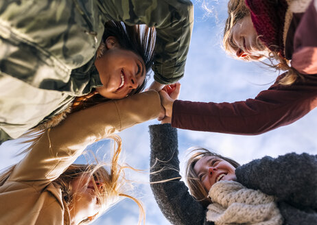 Four happy friends huddling outside - MGOF02917