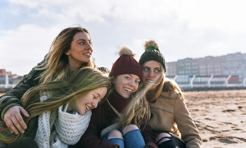 Vier glückliche Freunde verbringen gemeinsam Zeit am Strand, lizenzfreies Stockfoto