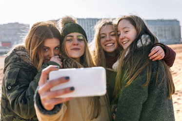 Vier Freunde nehmen Selfie mit Handy am Strand - MGOF02933