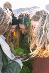 Four friends looking at cell phone - MGOF02934