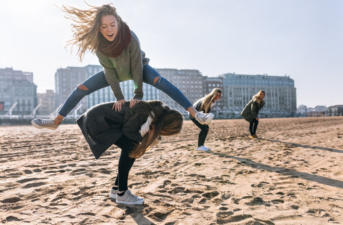 Vier Freunde spielen Bockspringen am Strand - MGOF02935