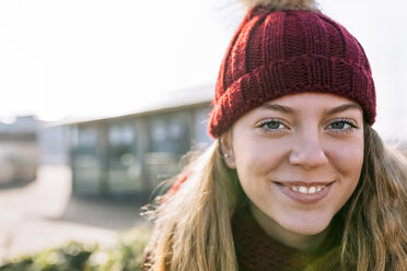 Portrait of smiling teenage girl wearing woolly hat - MGOF02955