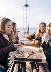Four friends eating pizza outdoors - MGOF02957