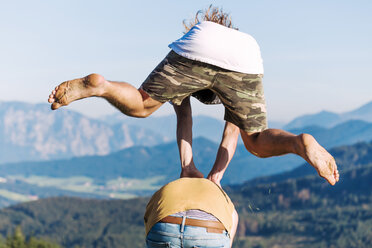 Austria, Mondsee, Mondseeberg, two young men leapfrogging - WVF00836